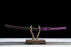 Full side view of 暗夜魔瞳 katana displayed with its black and blue crackle saya