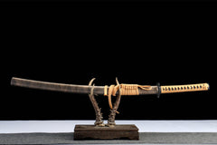 Wide studio view of 孤鸿影 katana and matching snakeskin-pattern saya on a wooden stand