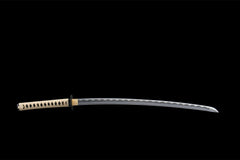 Close-up of 渡厄 blade showing the polished edge and wave temper pattern