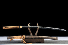 Close-up of 孤鸿影 blade and handle showing the polished white edge pattern on the blackened steel