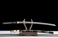 Detailed view of 断鸿 drawn beside the black crackle saya and ivory sageo