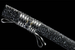 Textured close-up of 千机变 saya under light with its star-like speckled surface
